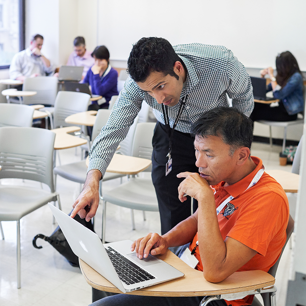 staff member helping student with a laptop